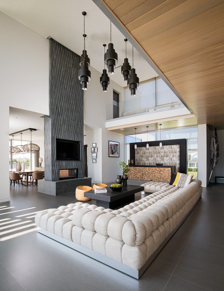 A modern living room with couches and a fireplace.