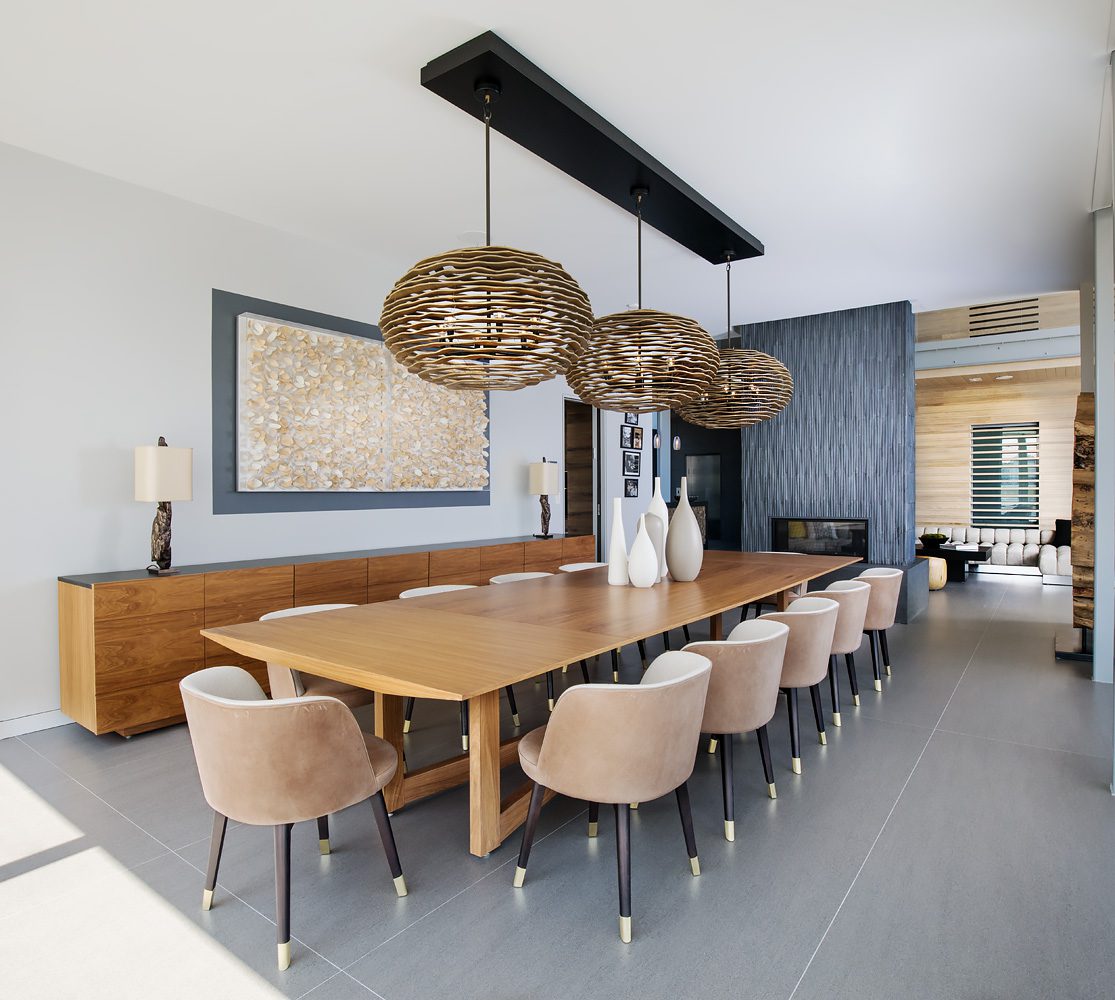 A dining room with a large table and chairs.