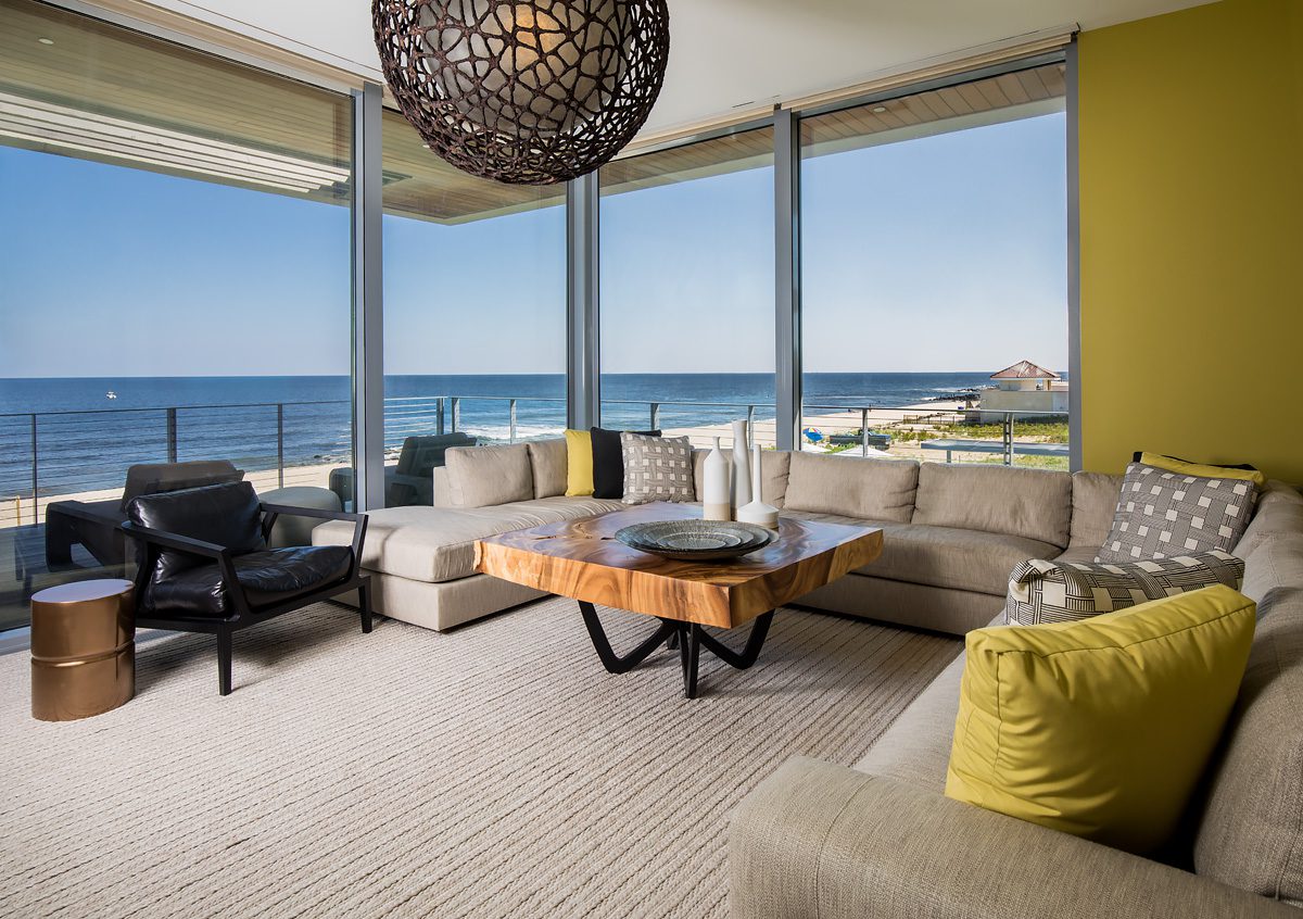 A living room with large windows overlooking the ocean.