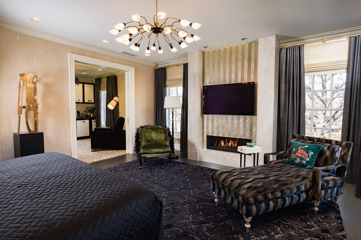 A black and gold bedroom with a fireplace.