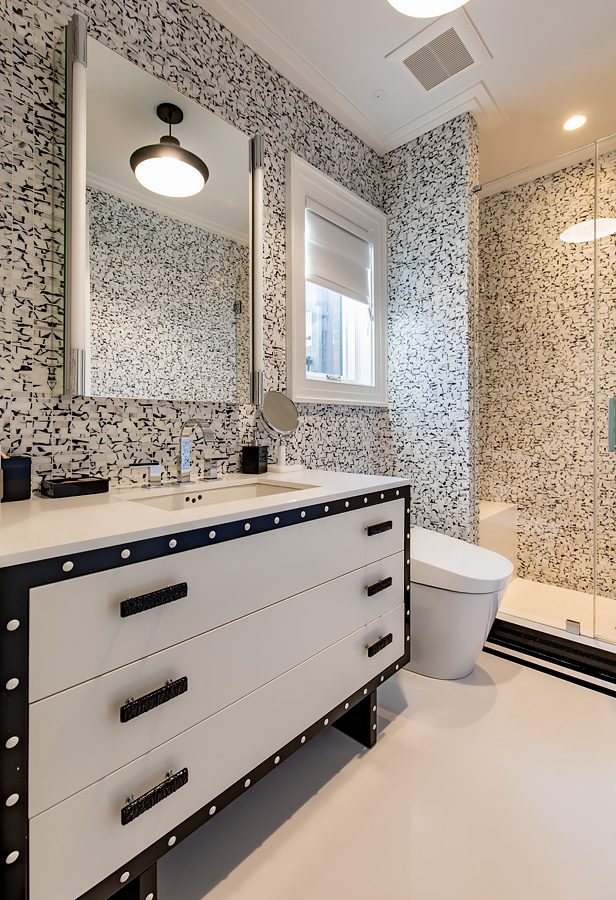 A bathroom with black and white tiled walls.