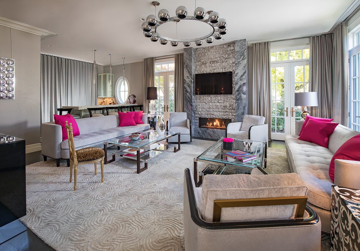 A living room with pink accents and a fireplace.