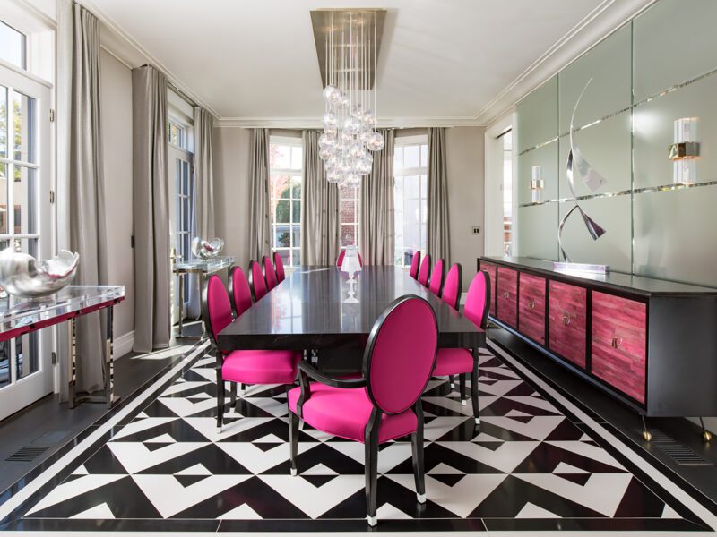 A black and white dining room with pink chairs.