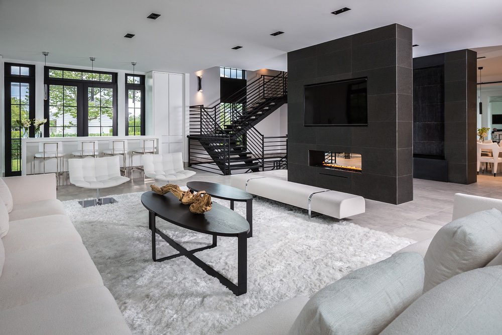 A modern living room with white furniture and a fireplace.