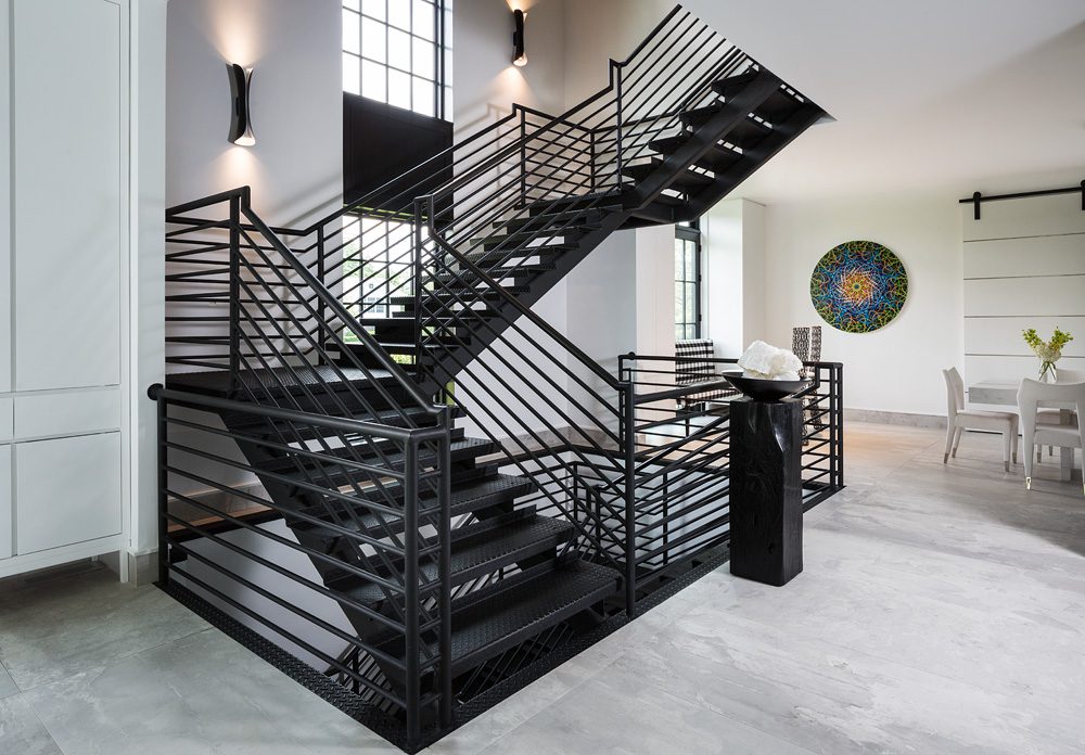 A modern staircase in a home with black railings.