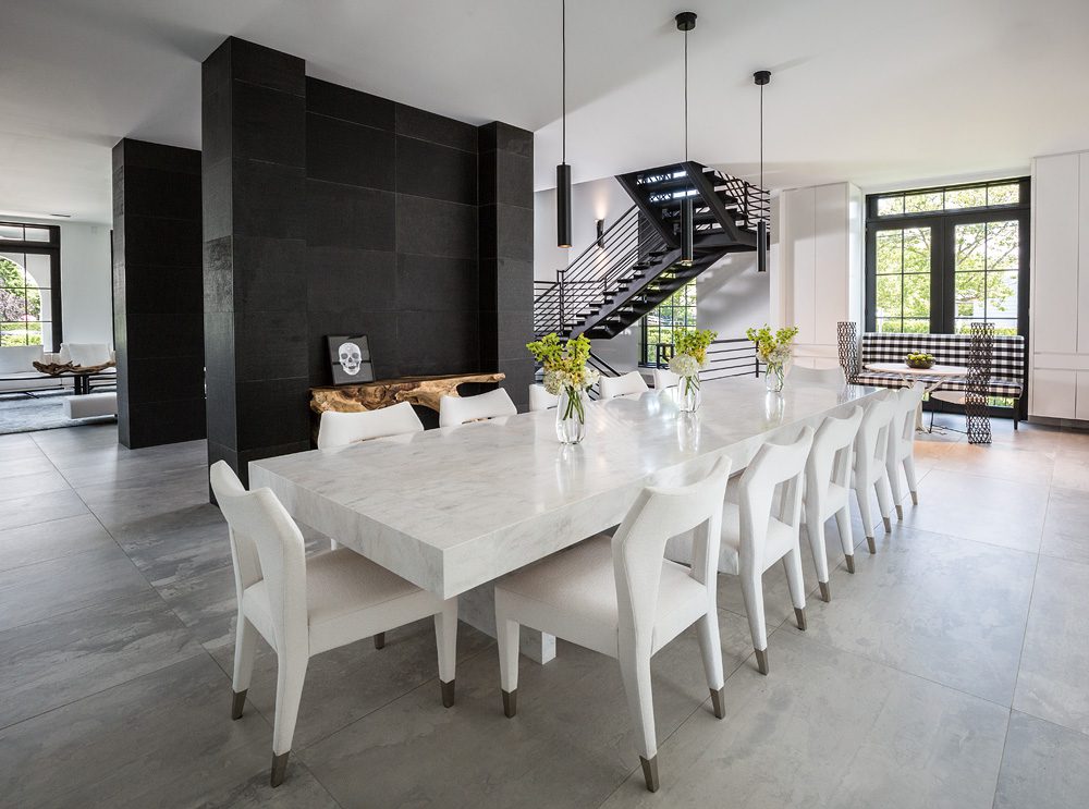 A modern dining room with a white table and chairs.