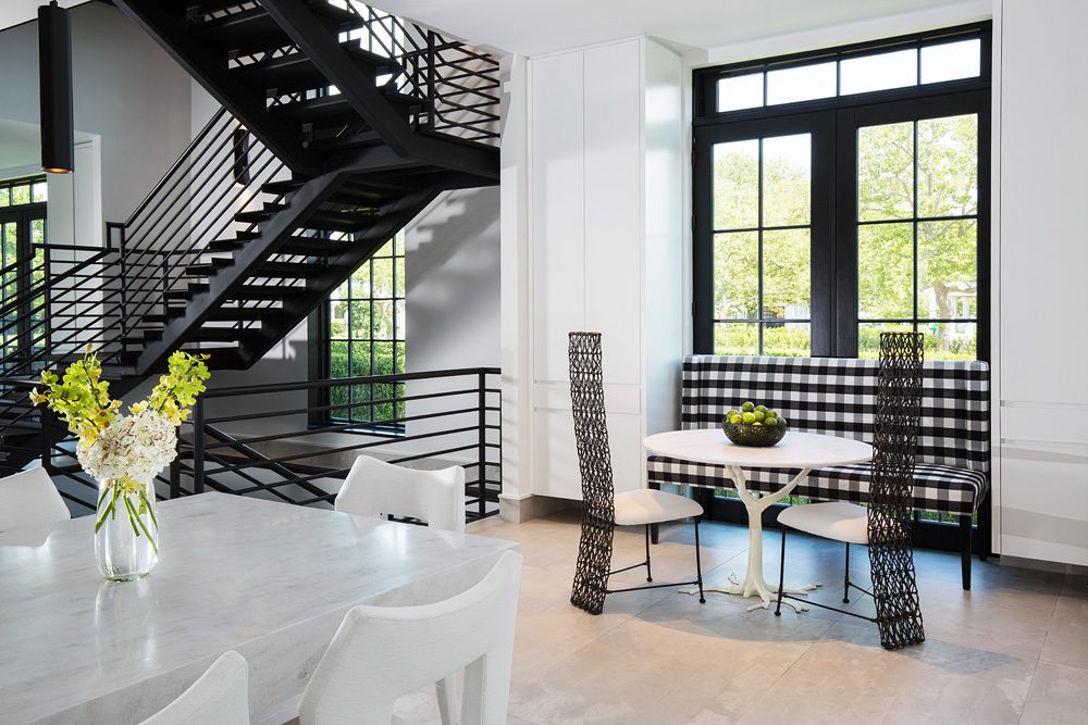 A dining room with a white table and black chairs.