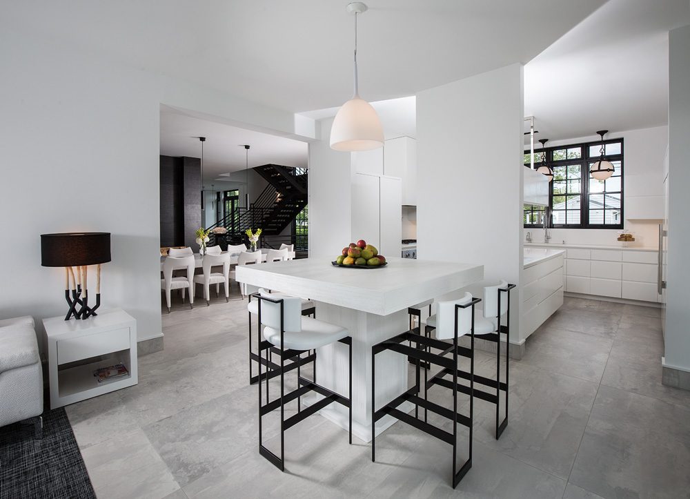 A white kitchen with stools and a dining table.