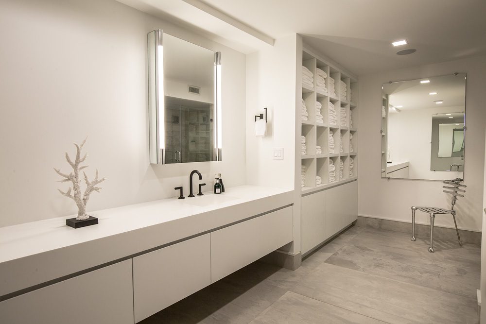 A white bathroom with a sink and mirror.