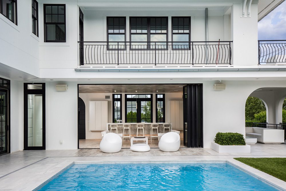 A white house with a pool and patio.