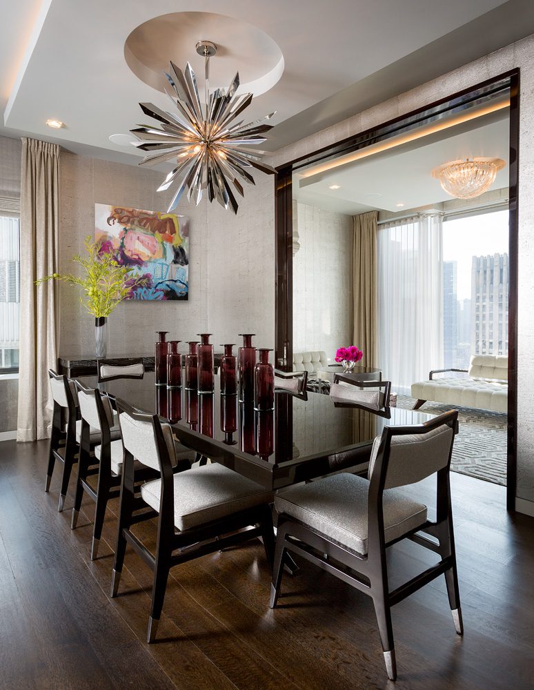 A dining room with a large table and chairs.